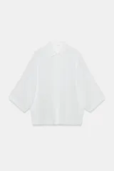 Camisa amplia ZW Collection de corte oversize, confeccionada en hilatura con lyocell y ramio, en color blanco. Presenta cuello solapa, manga por debajo del codo, detalle de pliegue en la espalda y cierre frontal con botones ocultos por solapa.