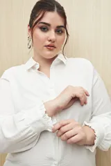 Camisa color café con textura sutil, cuello clásico, botones forrados a tono y mangas largas con puños fruncidos.