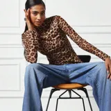 Top de microtul con estampado animal print de leopardo, doble tela, cuello alto y mangas largas.