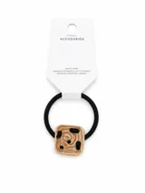 Colero negro para el pelo con elástico resistente y aplique decorativo cuadrado de metal dorado con diseño efecto carey marmolado en tonos marrones y beige, con detalles en negro.