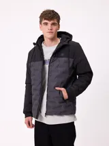 Campera con capucha, diseño bicolor en negro y gris oscuro, con panel frontal acolchado y mangas lisas. Cuenta con cierre frontal, bolsillos laterales y puños elásticos.