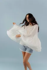 Camisa de algodón con diseño romántico, mangas amplias y detalles de puntillas verticales en el frente. Presenta un corte holgado y fluido.