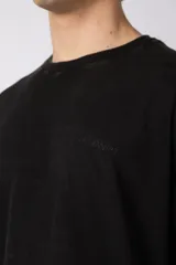 Remera de algodón gris con efecto acid wash, corte regular, mangas cortas y cuello redondo. Cuenta con un pequeño bordado tono sobre tono en el pecho y una etiqueta lateral distintiva de la marca en el ruedo.