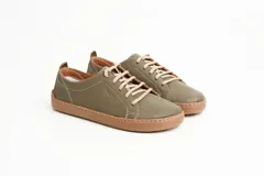 Zapatillas de cuero blanco con diseño minimalista, cordones al tono y suela de goma color suela con costura vista.
