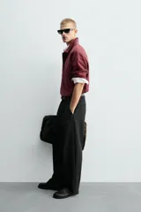 Polo boxy fit color bordó, confeccionado en tejido de algodón. Presenta cuello solapa, cierre frontal con botonadura oculta por solapa y manga larga.