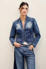 Saco de denim azul con efecto deslavado, corte entallado, cuello mao, mangas largas y cierre frontal con botones metálicos. Cuenta con bolsillos frontales appliquéd y un diseño de costuras estructuradas con dobladillo en punta.