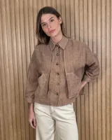 Sobrecamisa de lino color marrón, de corte oversize, con bolsillos frontales y cierre de botones.