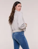 Camperita bomber de lyocell con textura suave, color azul marino, cuello camisero, cierre frontal con botones a presión, bolsillos laterales con solapa, mangas largas con puños elásticos y pretina fruncida en el ruedo.