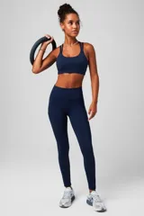 Top deportivo de bajo impacto en color azul marino, con escote redondo y diseño de doble bretel fino. Confeccionado en tejido técnico elástico, ideal para actividades de baja intensidad.