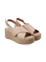 Sandalia de plataforma tipo yute con tiras cruzadas de cuero en color beige, y tira ajustable al talón con hebilla metálica.