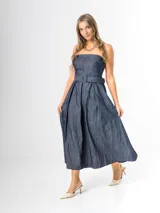 Vestido midi strapless de denim azul, con escote recto, espalda elastizada y falda amplia con pliegues. Incluye un cinto del mismo material con hebilla.