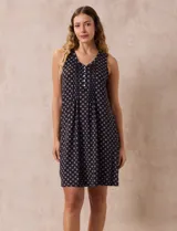 Camisón corto negro con estampado de lunares blancos, escote en V con botones y detalle plisado en el pecho.