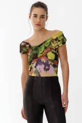 Top de tul estampado con diseño cruzado en el frente y escote tipo bote que deja los hombros al descubierto. Presenta un patrón abstracto en tonos verdes, amarillos, rosados y negros.
