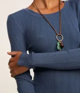 Suéter de punto acanalado color beige, con cuello redondo y mangas largas. Confeccionado en tejido tricot con textura suave y ajuste al cuerpo.