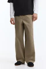 Pantalón relaxed fit en mezcla de algodón, de color beige, con cintura elástica ajustable mediante cordón, bragueta con botón y costuras decorativas giradas en las piernas.