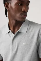 Polo de manga corta Levi's en color gris jaspeado, con cuello clásico y cierre frontal de dos botones. Presenta un pequeño logo bordado en el pecho.