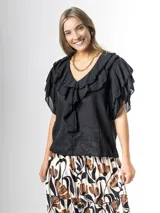 Blusa negra de algodón con escote en V y volados frontales, de mangas cortas fluidas.