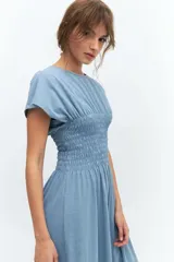 Vestido midi celeste con cuello redondo, mangas cortas y cintura elastizada con punto panal.