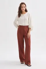 Pantalón ancho de viscosa color marrón, con pinzas frontales y tiro alto.