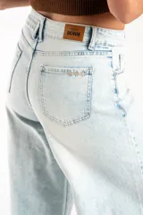 Jean de corte wide leg con tiro medio, confeccionado en denim de algodón con un lavado claro desgastado. Presenta diseño de cinco bolsillos y cierre frontal con botón y cremallera.