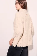 Sweater color crema con cuello alto, tejido de punto con textura y mangas largas con puños acampanados.