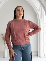 Sweater rosado de tejido de punto con cuello alto y mangas largas con diseño de trenzas.