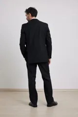 Traje de corte clásico compuesto por saco de dos botones y pantalón de vestir a juego. El saco presenta solapas tradicionales y bolsillos con solapa, mientras que el pantalón tiene un corte recto y formal.