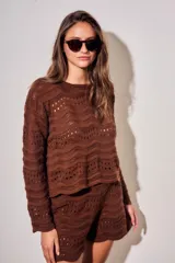 Sweater oversize de tejido de punto color marrón, con diseño texturado a rayas horizontales ajadas, cuello redondo y mangas largas.
