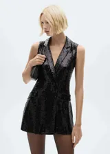 Mono corto de fiesta color negro con lentejuelas, cuello con solapa, sin mangas, bolsillos de ribete y forro interior.