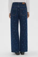 Pantalón de jean azul con estampado de lunares, tiro alto, pinzas en la cintura y corte ancho.