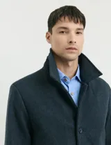 Sobretodo corto de lana con diseño de espiga en color azul. Presenta cuello camisero, cierre frontal con botones y bolsillos laterales.