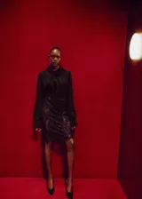 Blusa negra de viscosa con cuello redondo, detalle de fular anudado al cuello y volantes. Presenta mangas largas con puños abotonados y cierre frontal con botones.