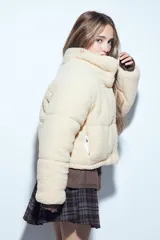 Campera puffer de corderito negro con cuello alto y diseño oversized. Presenta una textura tipo teddy, cierre frontal y corte a la cintura.