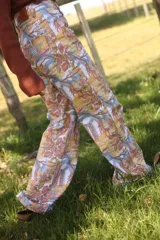 Pantalón tipo jean de corte recto con estampa artística exclusiva de la marca AZU, que combina motivos botánicos y tipografía en tonos tierra, rosados y azules.