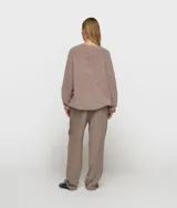 Sweater de punto oversize color marrón, con cuello en V y confeccionado en una mezcla de lana de alpaca. Presenta ribetes anchos en cuello, puños y bajo, con un diseño de hombros caídos y textura suave.