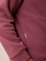 Canguro de polar azul con capucha y cordones ajustables. Presenta un bolsillo frontal tipo canguro y un pequeño logo bordado en el pecho.