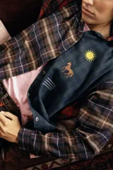 Camisa amplia de tela suave con diseño de combinación de estampas a cuadros en tonos rojo, marrón y verde, con mangas largas y detalles bordados en el frente.