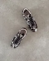 Zapatillas deportivas de cuero vacuno con estampado animal print de vaca en blanco y marrón.