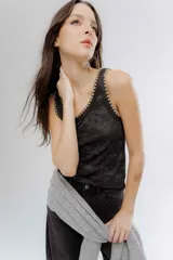 Musculosa de algodón y viscosa en color gris oscuro con efecto lavado, presenta un delicado bordado en hilo lurex dorado en el contorno del cuello y las sisas.