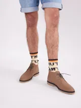 Botas de cuero color marrón claro con cordones verdes y suela de goma.