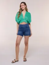 Short de denim blanco tiro alto, estilo pull-on con cintura elástica ancha, bolsillos delanteros y traseros, y dobladillo en las piernas.