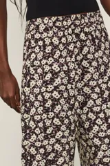 Pantalón ancho de viscosa con estampado floral en tonos oscuros, tiro medio con cintura elástica y aberturas laterales en los bajos.
