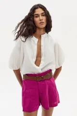 Short de lino color fucsia con cintura alta y cinturón de cuero trenzado marrón.