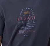 Remera T-shirt de algodón color gris oscuro con estampado frontal de estilo vintage con una motocicleta, texto "Authentic Legacy The Original" y "NYC".