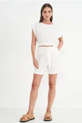 Blusa blanca crop top con mangas cortas amplias y cintura elastizada.