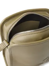 Cartera tipo reporter de piel sintética color verde oliva, con correa ajustable para llevar cruzada. Presenta el monograma 'CK' grabado en relieve en el frente, cierre de cremallera superior, bolsillo abierto trasero y tarjetero interior.