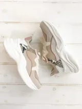 Sneakers con suela elevada y diseño chunky, en combinación de tonos beige, blanco, detalles en rosado y aplique con estampado de serpiente en el lateral.