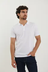 Polo de piqué color blanco, manga corta, con cuello y tapeta de botones al tono.