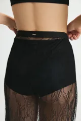 Pollera midi de encaje negro translúcido con terminación de puntilla en el ruedo. Presenta un diseño de tiro alto con cierre invisible lateral.