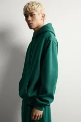 Sudadera con capucha de corte relajado, confeccionada en tejido de algodón con interior cepillado. Presenta manga larga, bolsillo frontal tipo canguro y acabados en rib en puños y bajo.